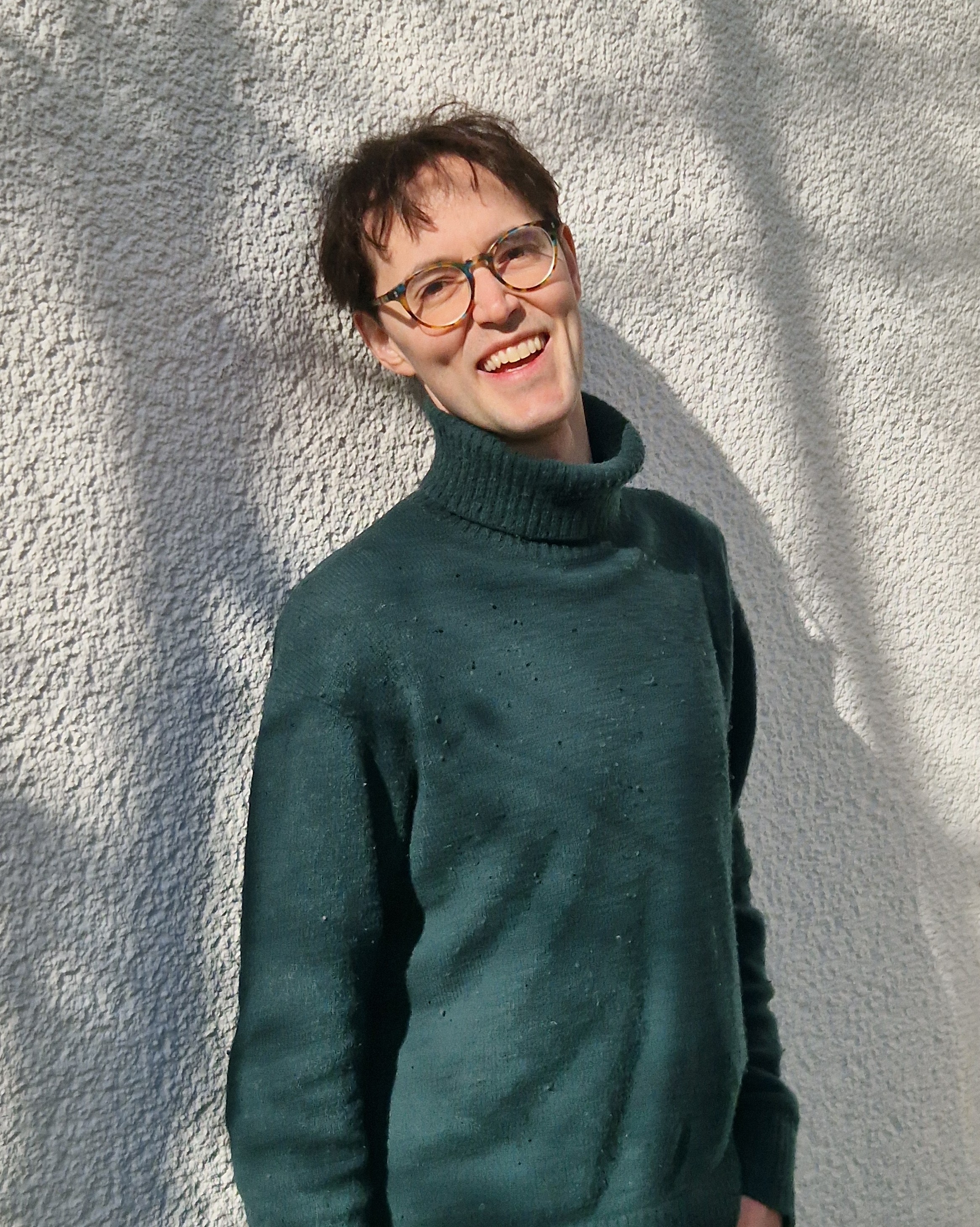 Tim Beyer smiling in front of white wall